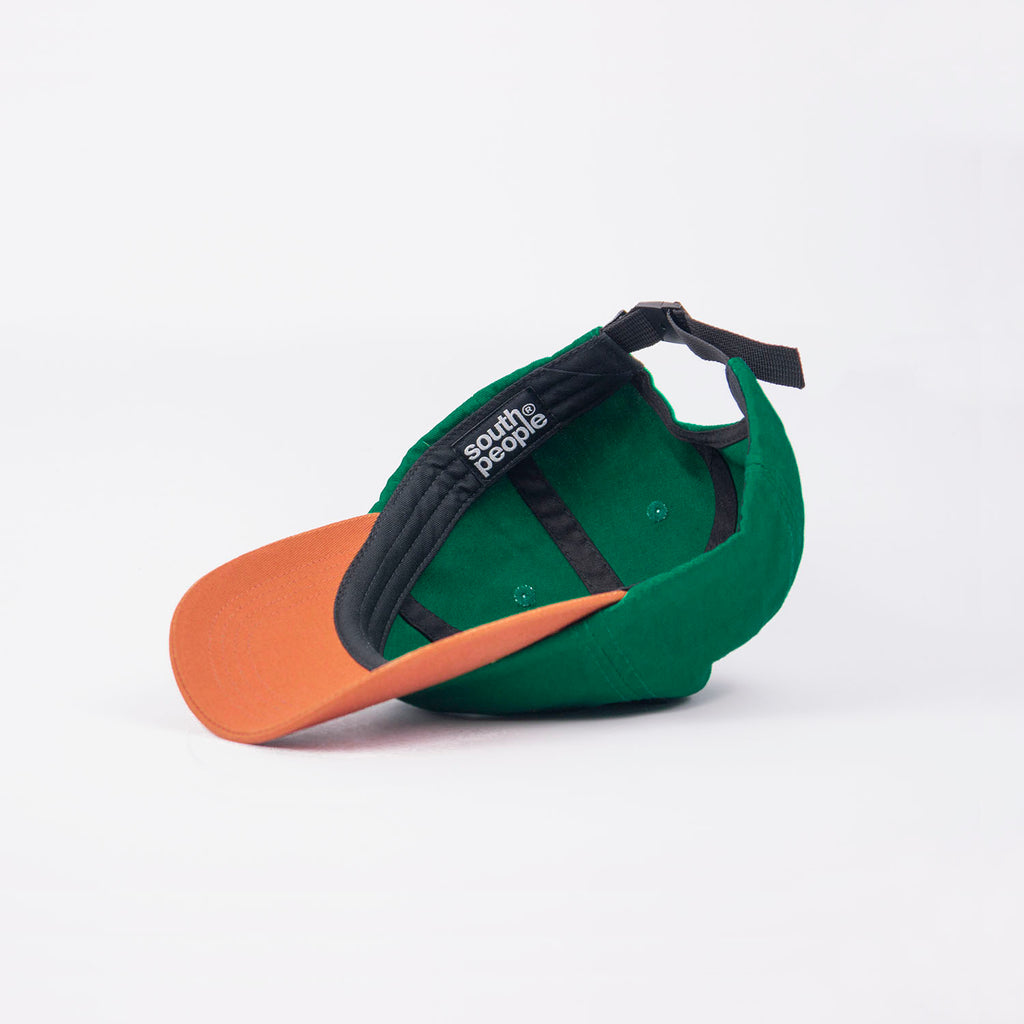 Interior gorra color verde con visera camel logo south people