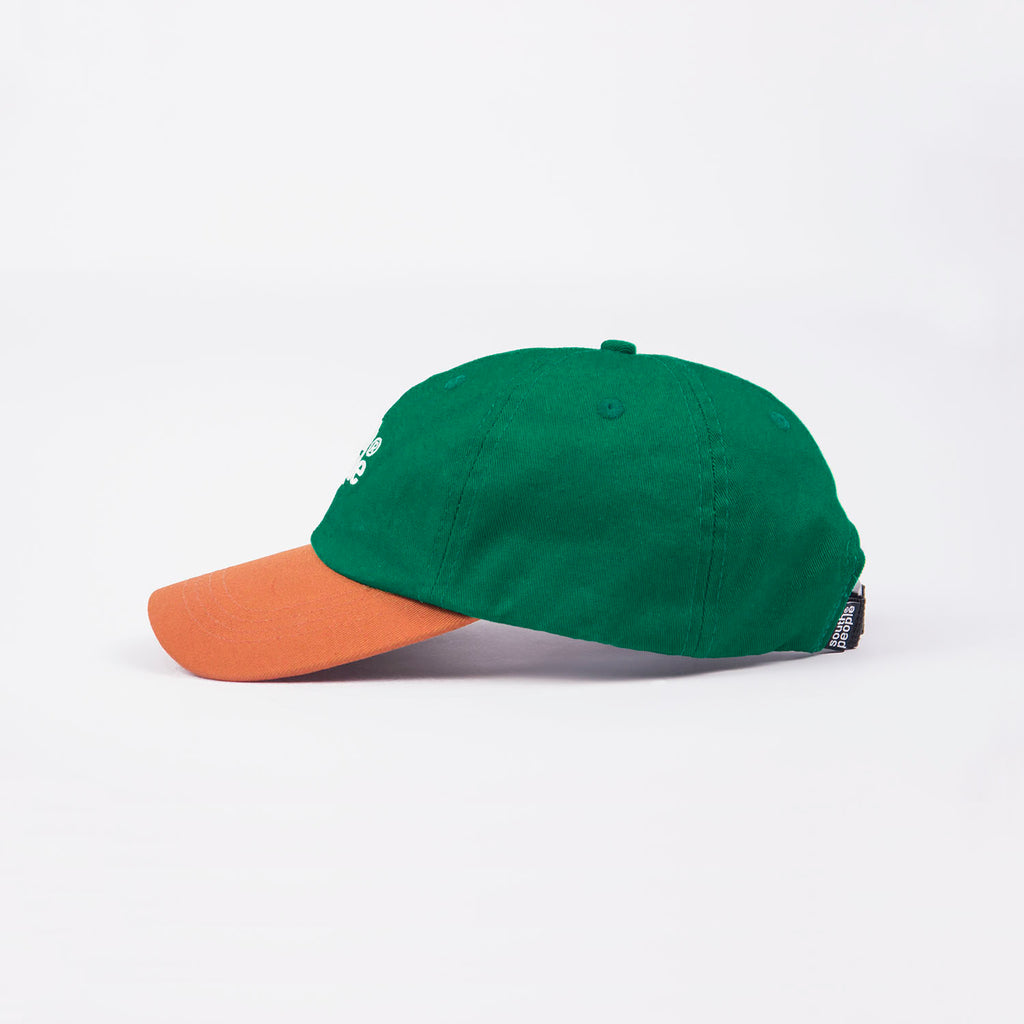 Lateral gorra color verde con visera camel logo south people